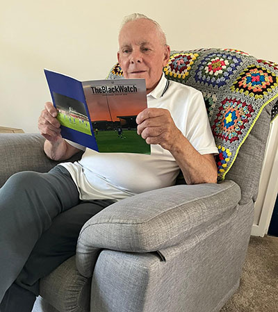 Tom Walker reading an issue of The Black Watch fanzine